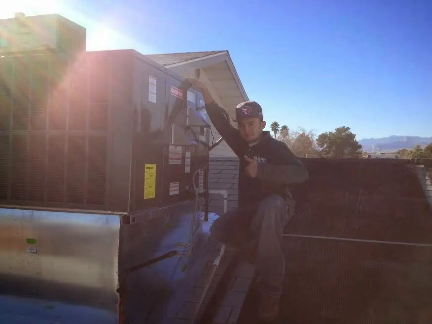 HVAC technician performing AC Tune-Up on a rooftop unit in Heeia